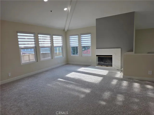 an empty room with fireplace and windows