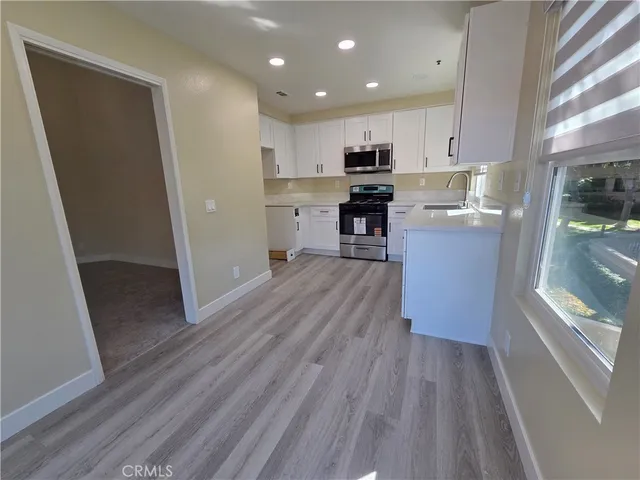 a kitchen with cabinets and wooden floor