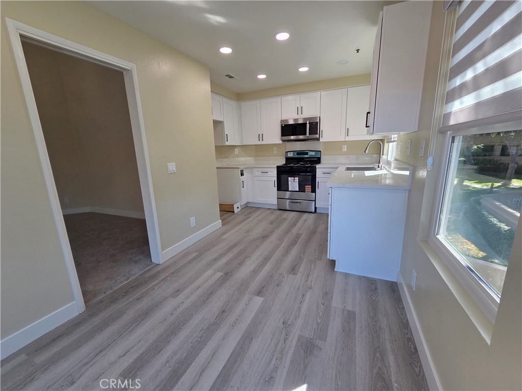 35 Ericson Aisle Irvine, CA 92620 - Photo 5 of 21 a kitchen with cabinets and wooden floor