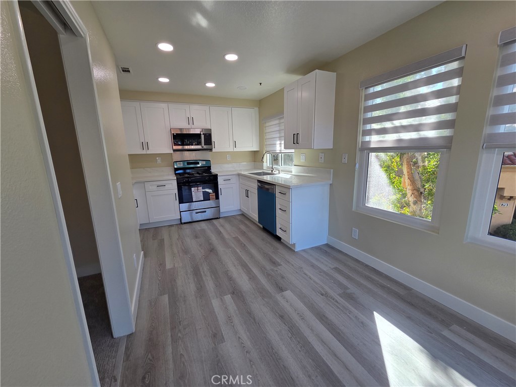 35 Ericson Aisle Irvine, CA 92620 - Photo 6 of 21 a open kitchen with kitchen island wooden floors and stainless steel appliances
