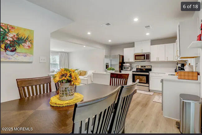 1001 Cypress Street Forked River, NJ 08731 - Photo 6 of 26 a kitchen with stainless steel appliances dining table and chairs