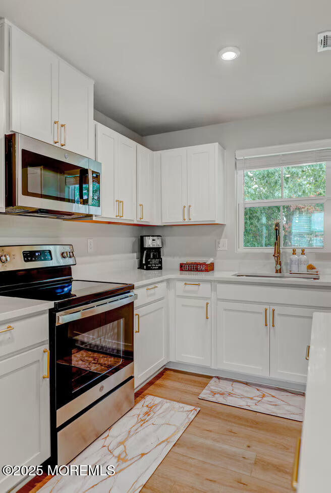 1001 Cypress Street Forked River, NJ 08731 - Photo 8 of 26 a kitchen with stainless steel appliances granite countertop a stove a sink and a microwave