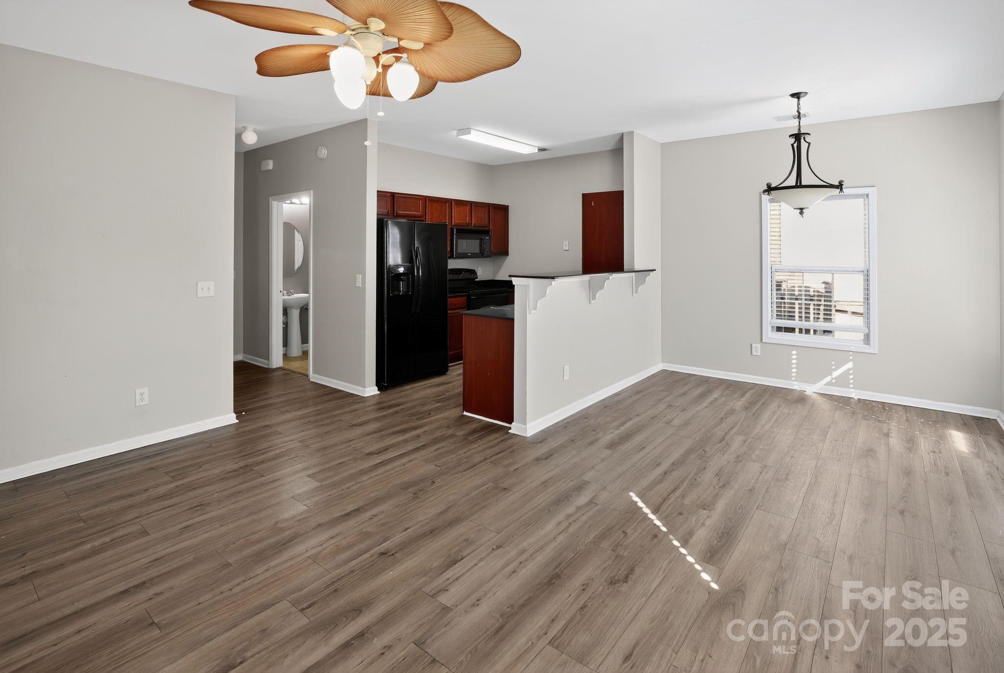105 Whitton Court Lexington, SC 29073 - Photo 16 of 33 a view of a room with wooden floor ceiling fan and kitchen view