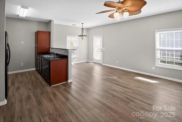 a view of a kitchen with wooden floor and electronic appliances