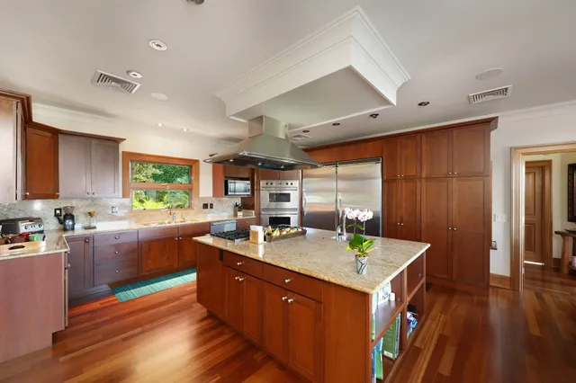 a kitchen with stainless steel appliances granite countertop a sink stove and wooden cabinets