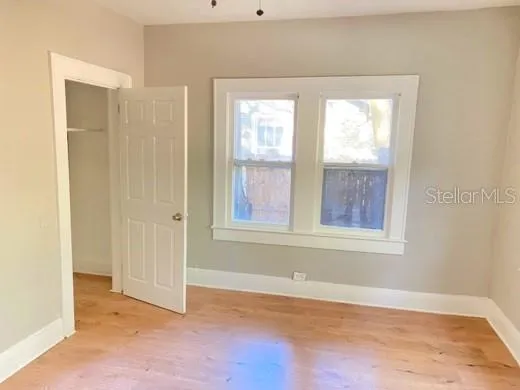 an empty room with windows and closet