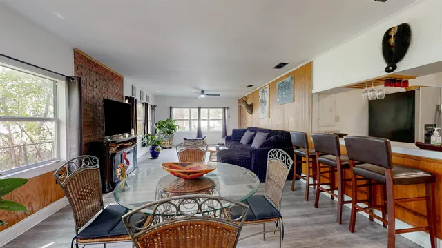 a living room with furniture a flat screen tv and a large window