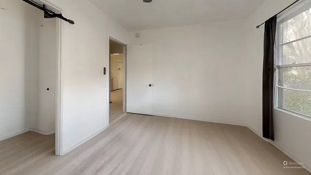 a bed sitting in a bedroom next to a window