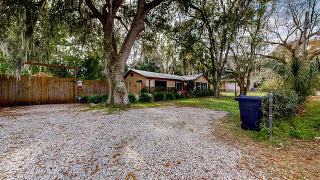 a front view of a house with a yard and tree