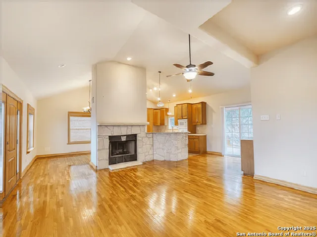 a view of a livingroom with a fireplace a chandelier and wooden floor