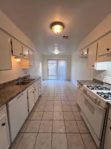 a kitchen with stainless steel appliances granite countertop a stove a sink and a microwave