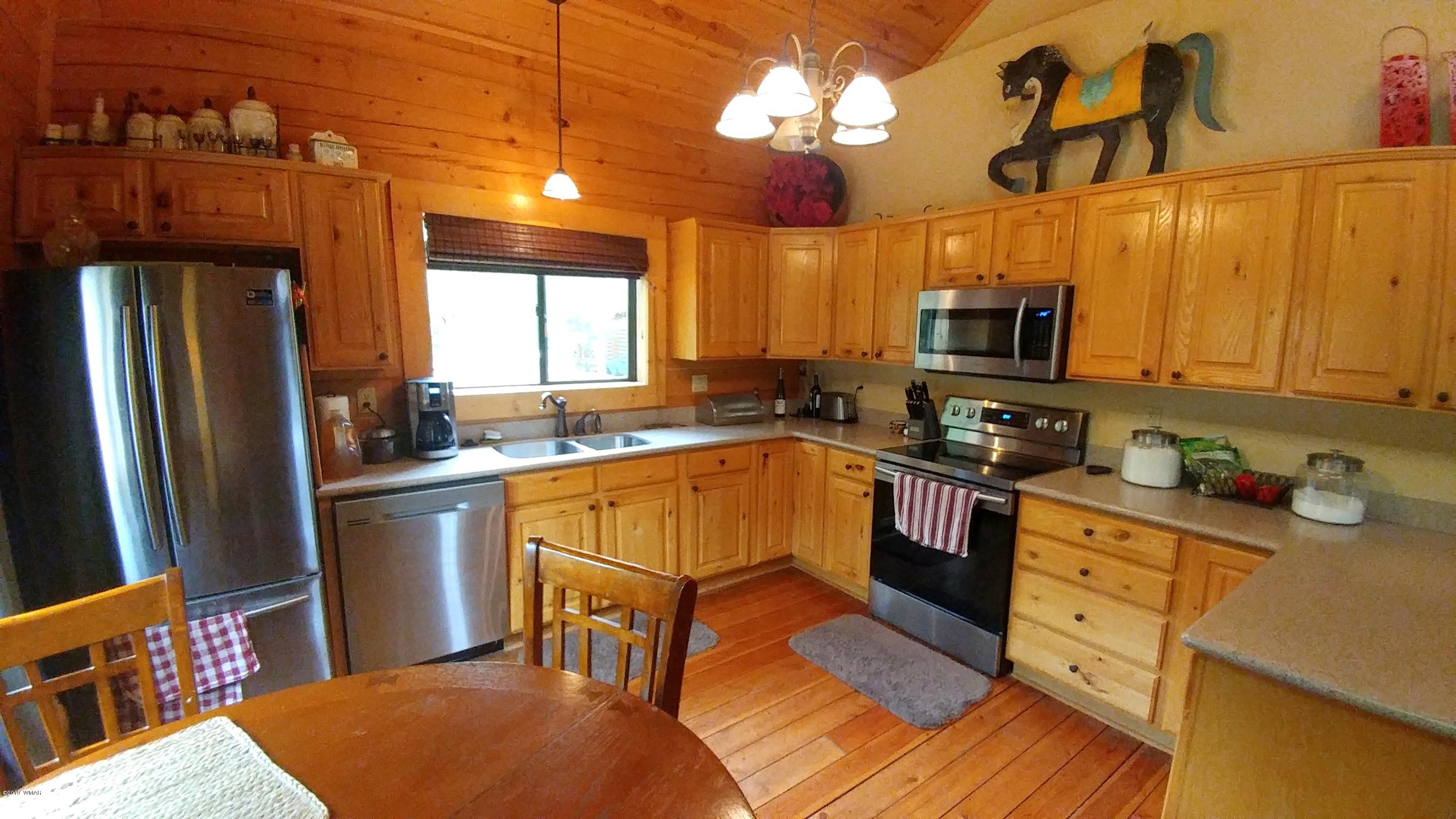 2312 Overgaard Springs Loop Overgaard, AZ 85933 - Photo 15 of 54 a kitchen with stainless steel appliances granite countertop a refrigerator a sink dishwasher a stove and white cabinets with wooden floor