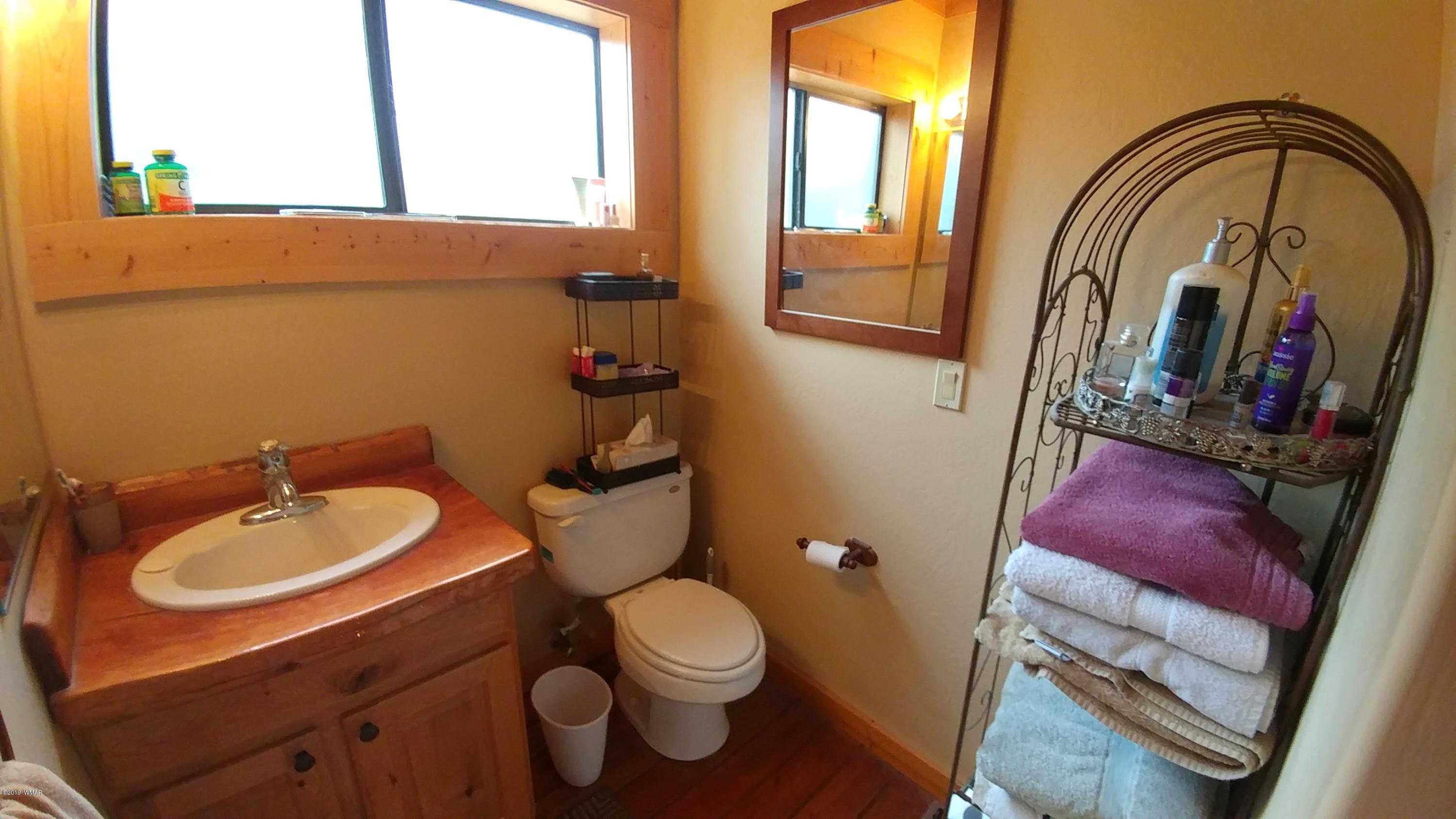 2312 Overgaard Springs Loop Overgaard, AZ 85933 - Photo 22 of 54 a bathroom with a toilet sink and mirror