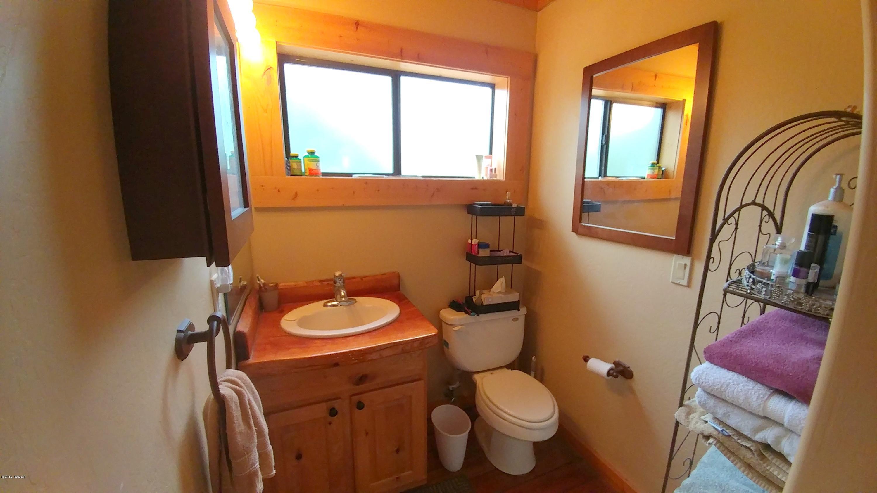 2312 Overgaard Springs Loop Overgaard, AZ 85933 - Photo 23 of 54 a bathroom with a toilet sink and mirror