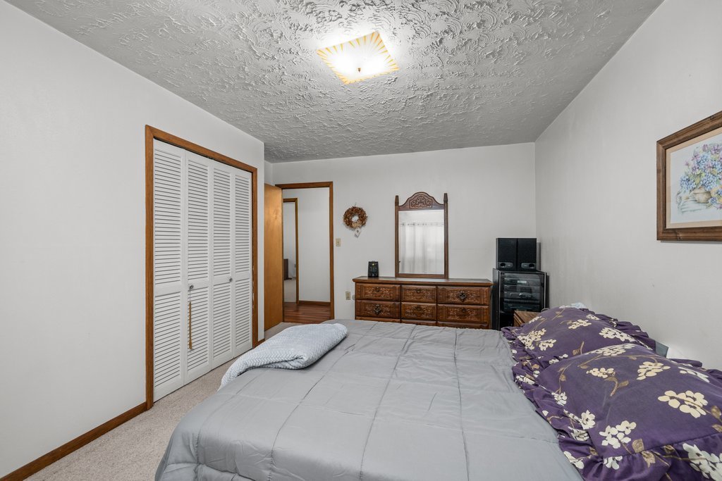 11213 22nd Street Milan, IL 61264 - Photo 8 of 36 a bedroom with a large bed and a chandelier