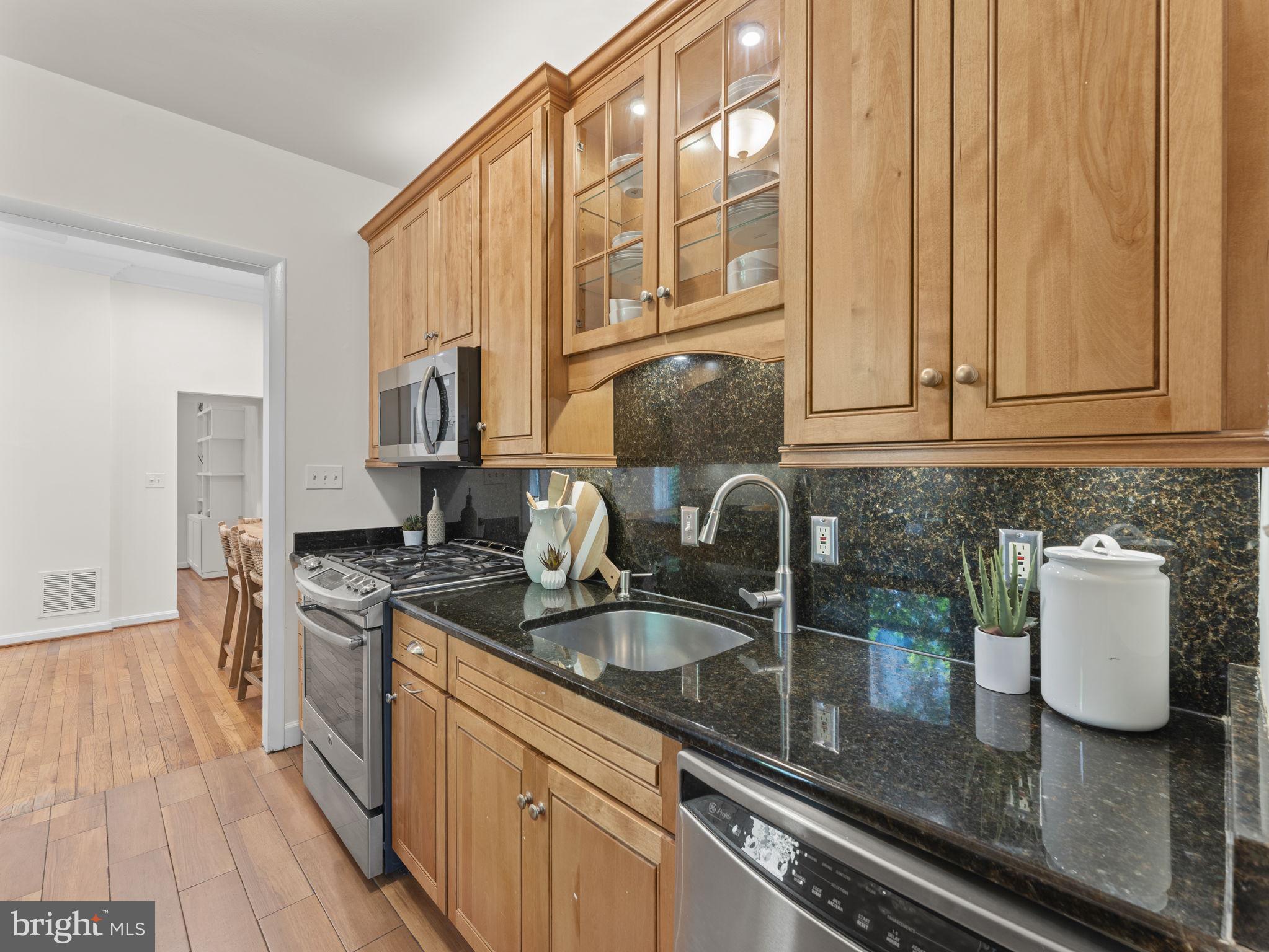 407 5th Street Northeast Washington, DC 20002 - Photo 15 of 41 a kitchen with granite countertop a sink stove and cabinets