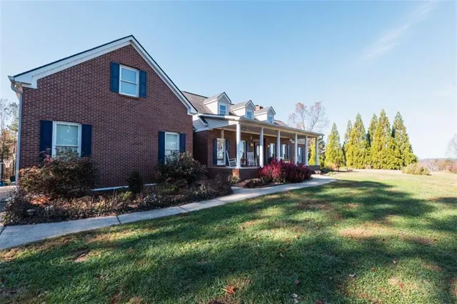 a view of a house with a patio and a yard