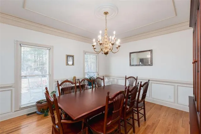 a dining room with furniture a chandelier and wooden floor