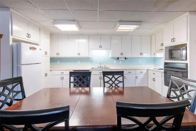 a kitchen with granite countertop white cabinets and white appliances