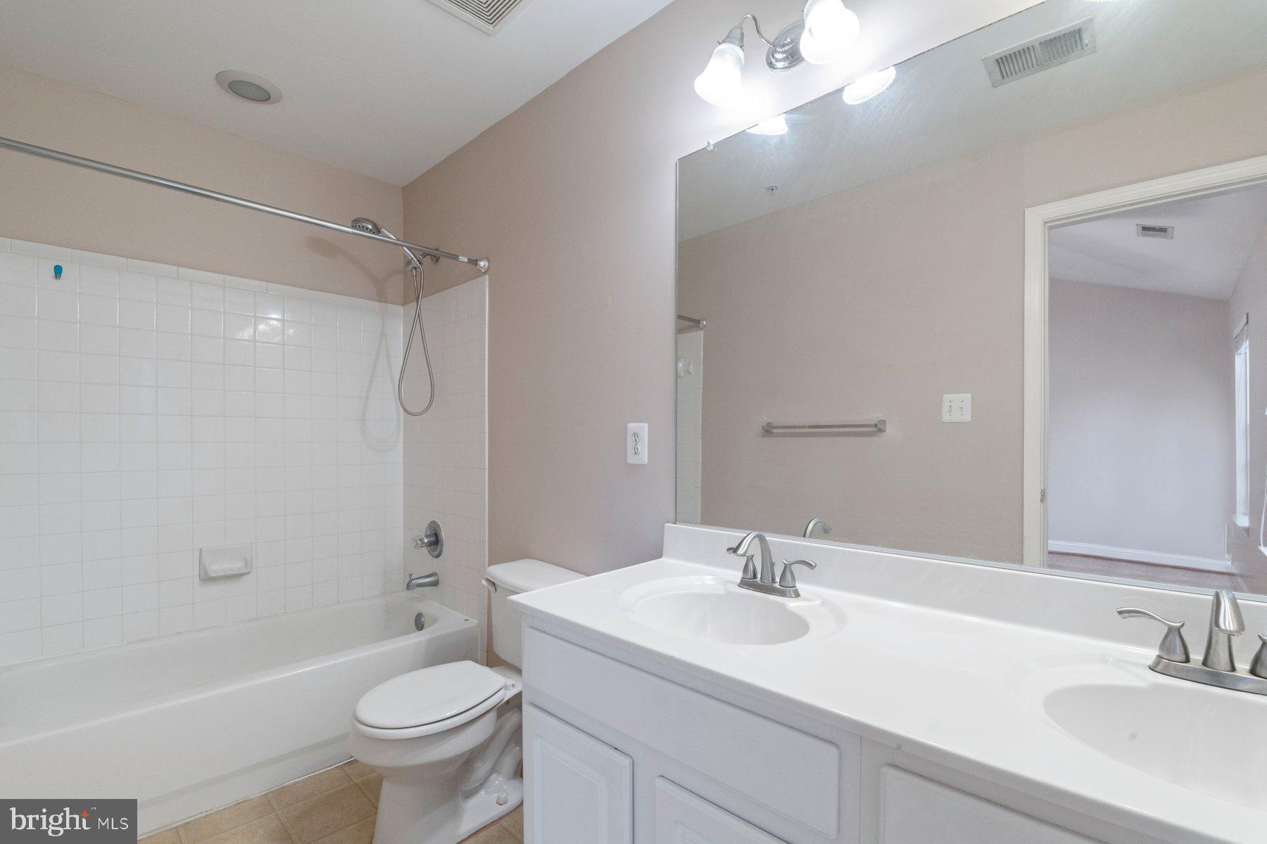 12802 Brightwell Drive Clarksburg, MD 20871 - Photo 21 of 30 a bathroom with a sink a toilet a mirror a bathtub and shower
