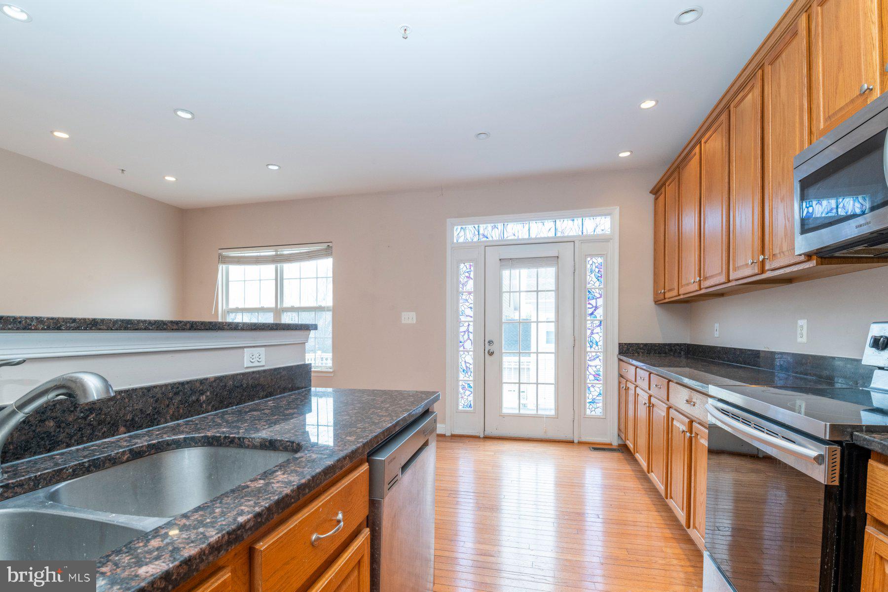 12802 Brightwell Drive Clarksburg, MD 20871 - Photo 3 of 30 a kitchen with stainless steel appliances granite countertop a sink stove and cabinets