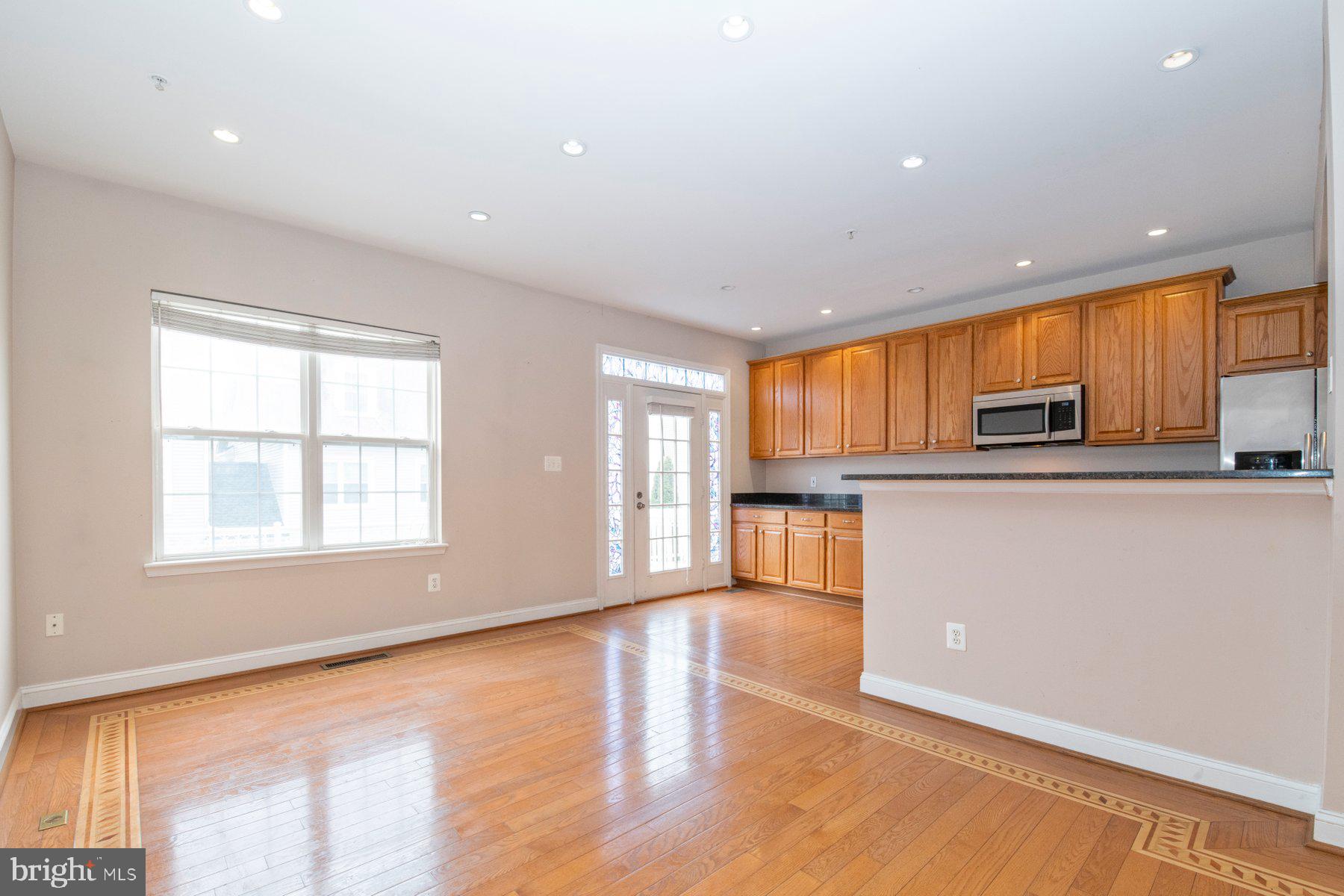 12802 Brightwell Drive Clarksburg, MD 20871 - Photo 7 of 30 a kitchen with stainless steel appliances granite countertop a refrigerator a sink dishwasher a stove and white countertops with wooden floor