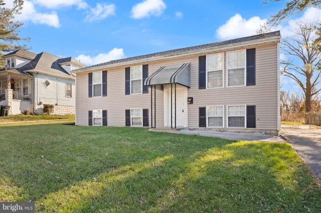 a brick house with a big yard and front view of a house