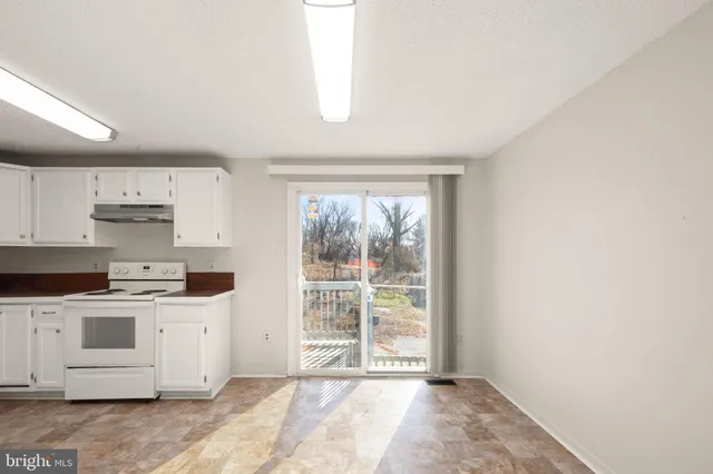 a kitchen with stainless steel appliances a stove a sink and white cabinets