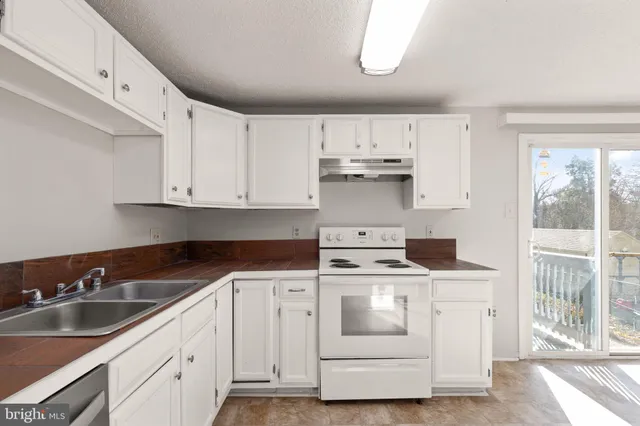 a kitchen with white cabinets and white appliances