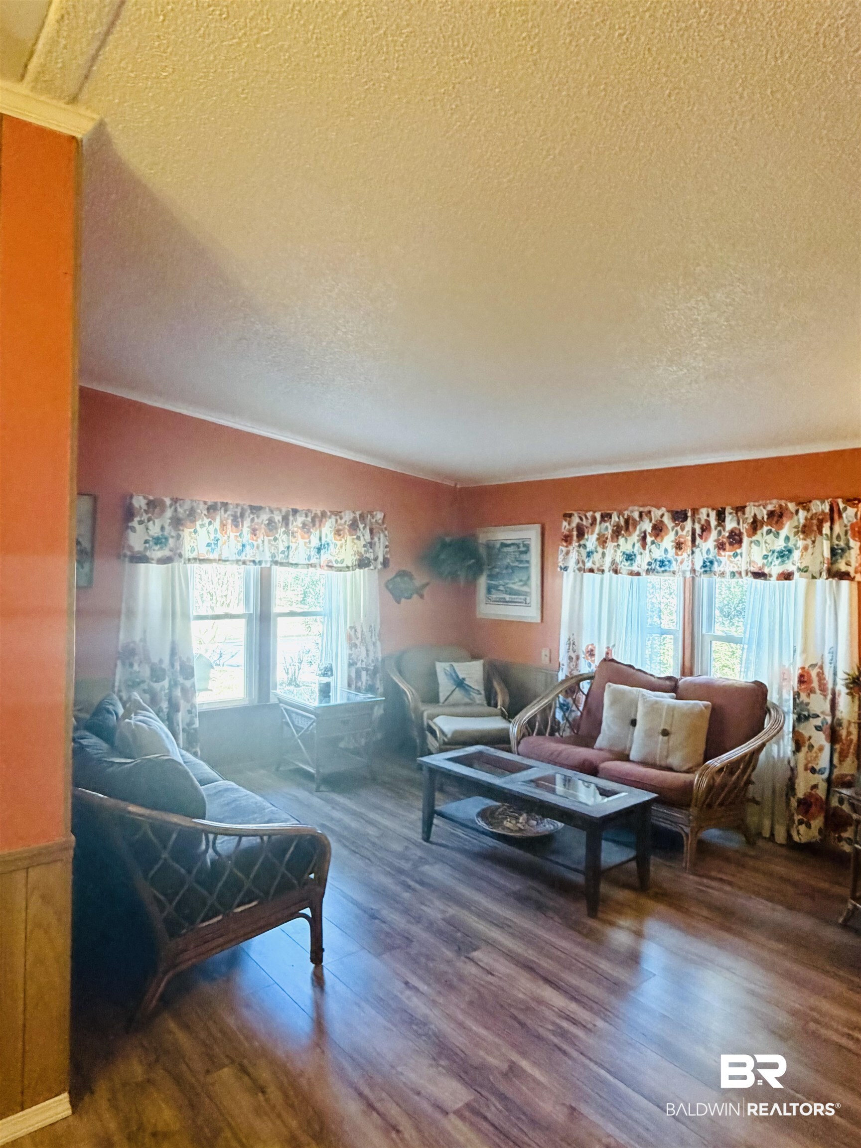 1127 Ridgewood Drive Lillian, AL 36549 - Photo 2 of 32 Living area featuring a textured ceiling, healthy amount of natural light, and wood finished floors