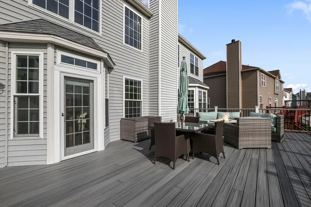 a view of a rooftop deck with couch and chairs