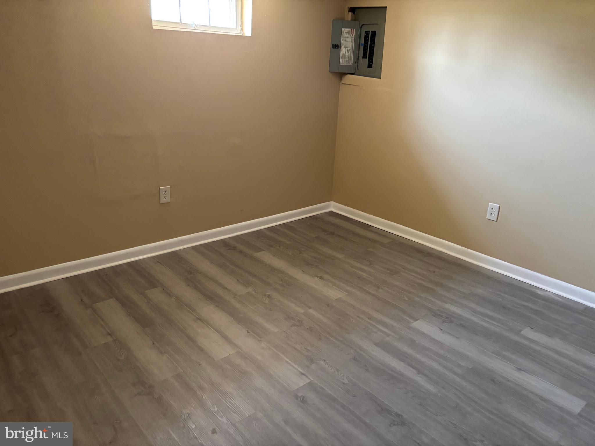 9016 Samoset Road Randallstown, MD 21133 - Photo 18 of 36 a view of an empty room with wooden floor and a window
