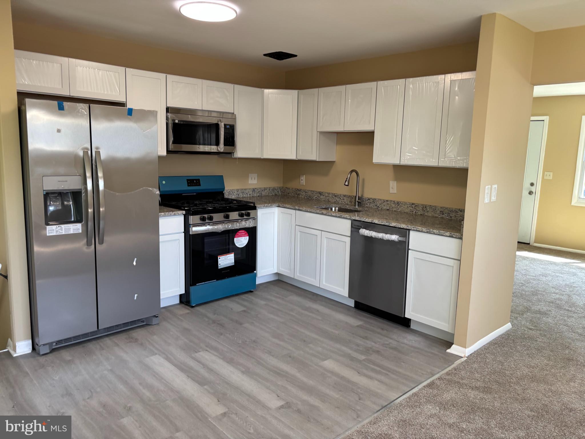 9016 Samoset Road Randallstown, MD 21133 - Photo 2 of 36 a kitchen with stainless steel appliances granite countertop a stove a refrigerator and a microwave