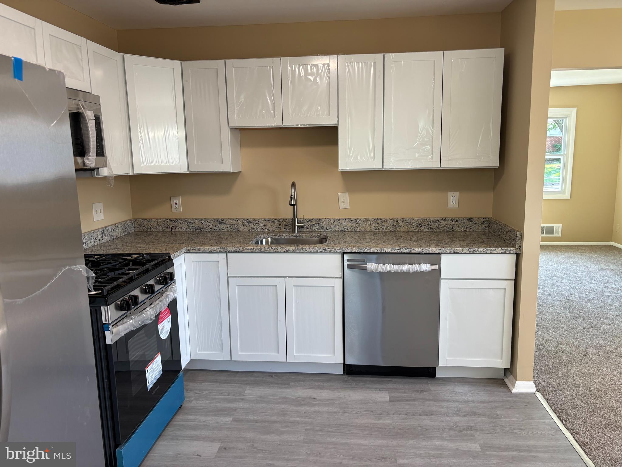 9016 Samoset Road Randallstown, MD 21133 - Photo 3 of 36 a kitchen with stainless steel appliances granite countertop a stove a sink and a microwave