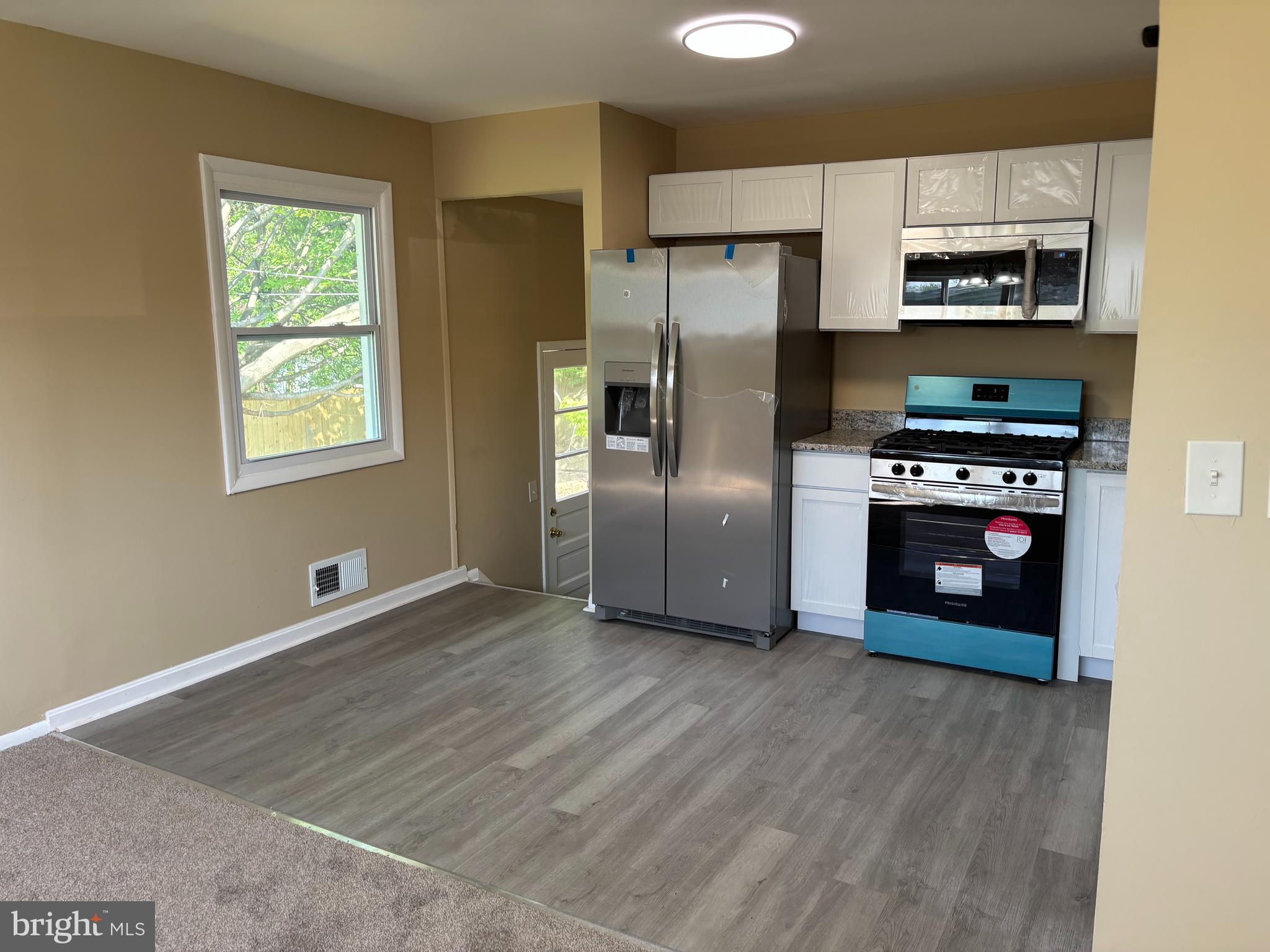 9016 Samoset Road Randallstown, MD 21133 - Photo 4 of 36 a kitchen with stainless steel appliances a stove a refrigerator and a microwave