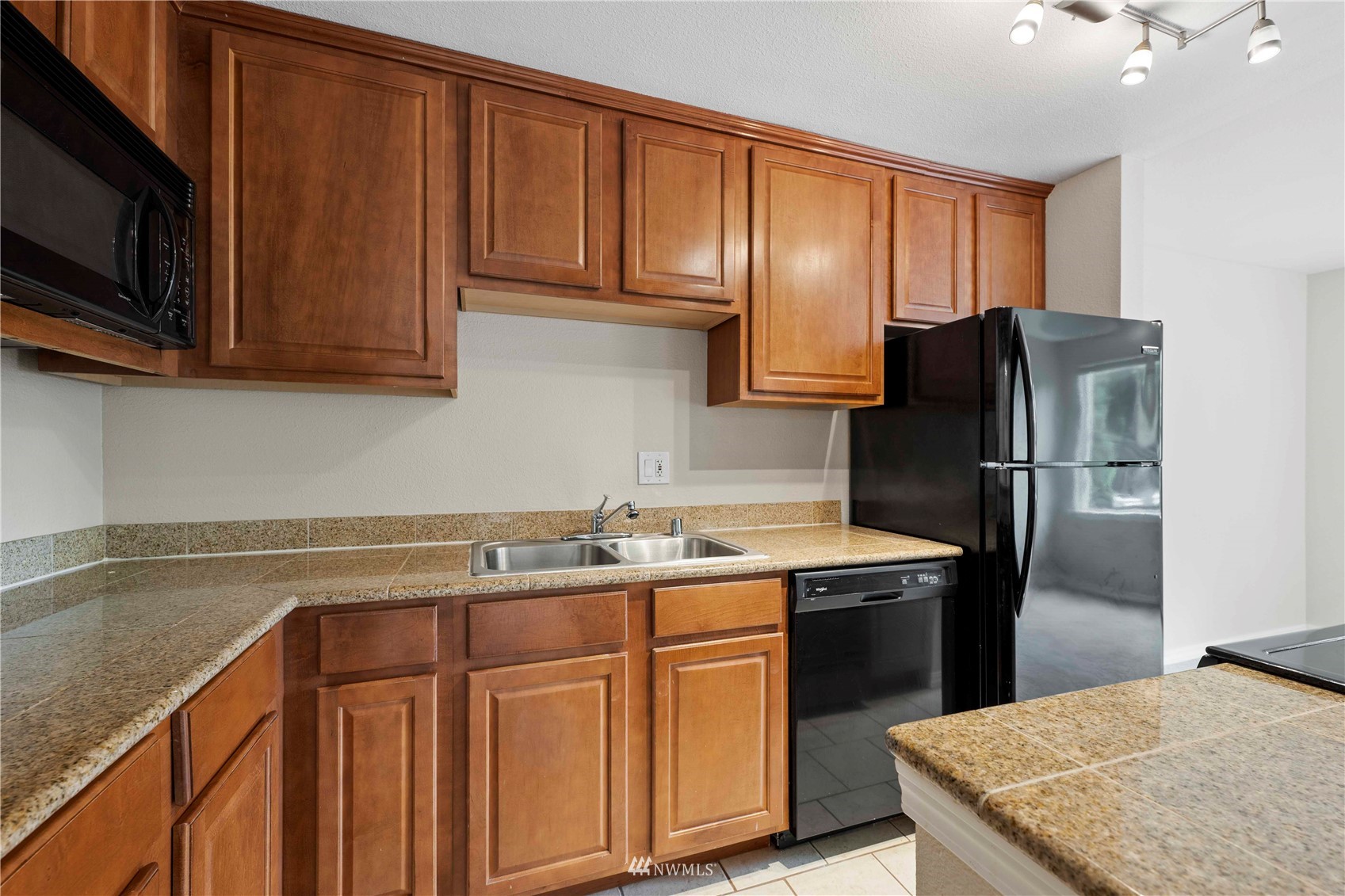 20318 Bothell Everett Highway, Unit A202 Bothell, WA 98012 - Photo 3 of 28 a kitchen with stainless steel appliances granite countertop a refrigerator stove top oven and sink