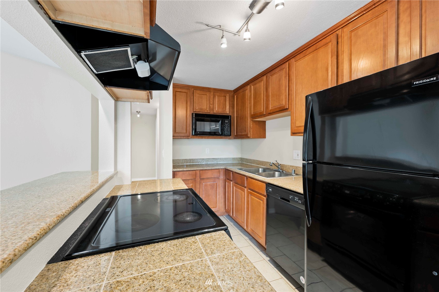20318 Bothell Everett Highway, Unit A202 Bothell, WA 98012 - Photo 5 of 28 a kitchen with stainless steel appliances granite countertop a sink a stove and a refrigerator