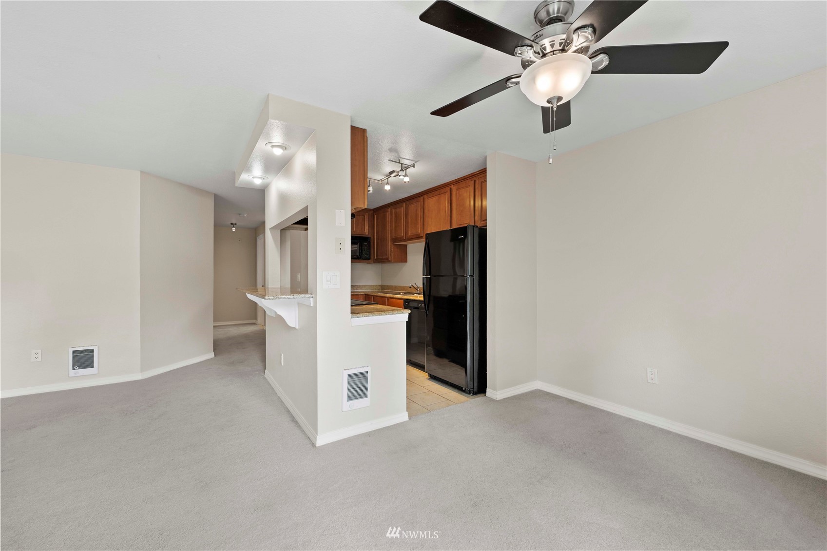 20318 Bothell Everett Highway, Unit A202 Bothell, WA 98012 - Photo 10 of 28 a view of a kitchen with refrigerator and a ceiling fan