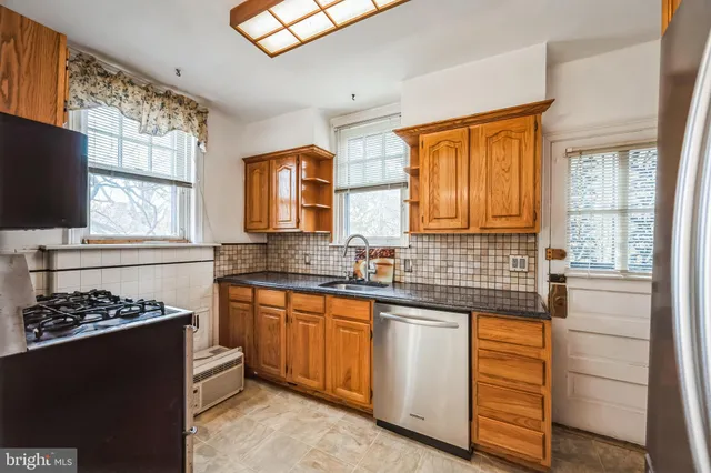 a kitchen with stainless steel appliances kitchen island granite countertop a stove a sink and a refrigerator