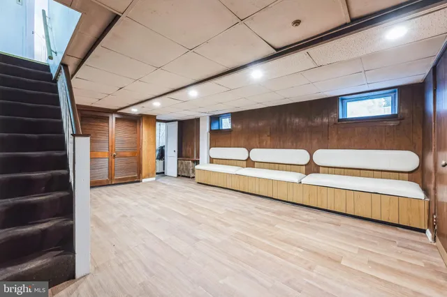 a view of an empty room with wooden floor and windows