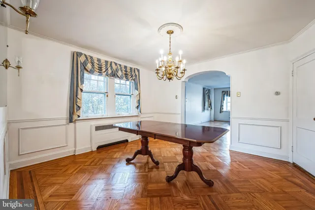 a room with chandelier and wooden floor