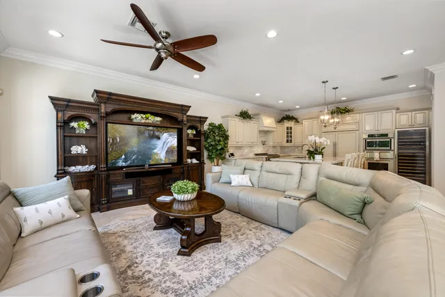 a view of a white house with large windows and a small yard