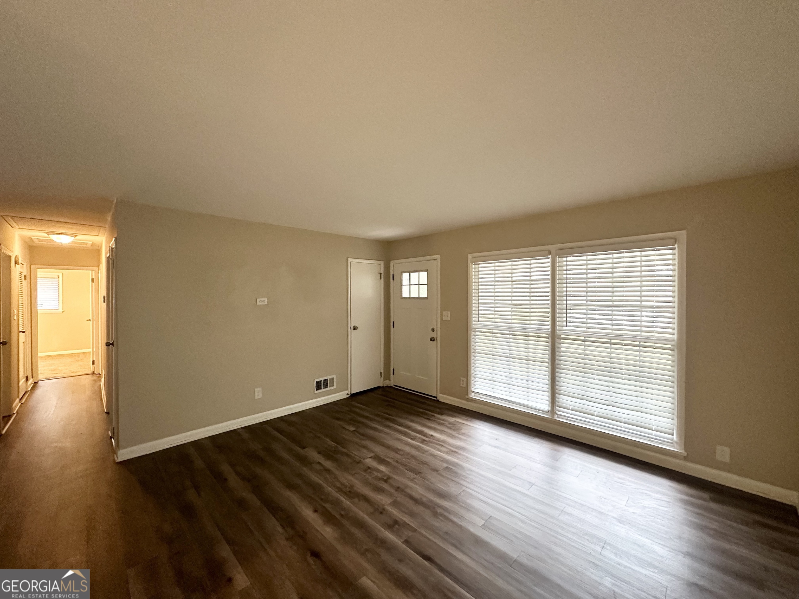 1519 Pine Glen Circle Decatur, GA 30035 - Photo 4 of 10 an empty room with wooden floor and windows with curtains