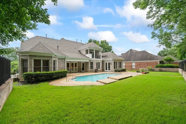 a view of swimming pool with seating area and trees in the background