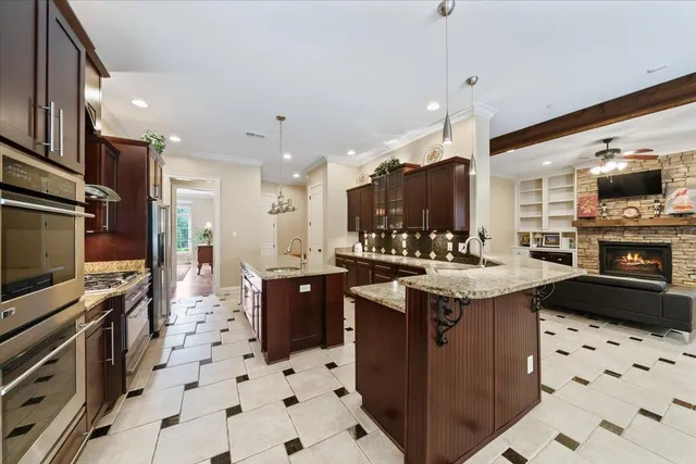 a kitchen with granite countertop a refrigerator a sink a stove and island