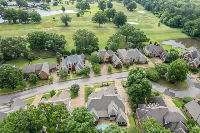 an aerial view of residential houses with outdoor space and lake view