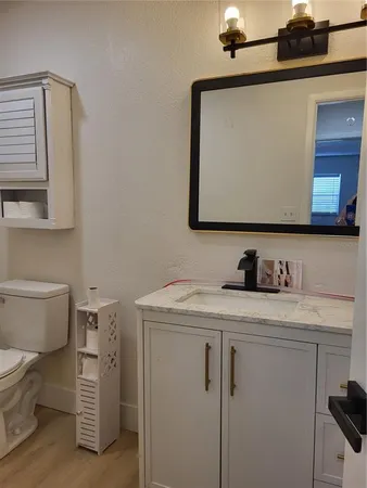 a bathroom with a granite countertop toilet sink and mirror