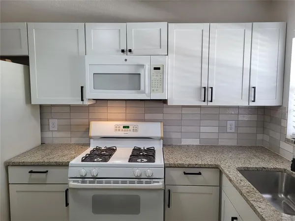 a stove top oven sitting inside of a kitchen