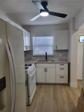 a kitchen with white cabinets and white appliances