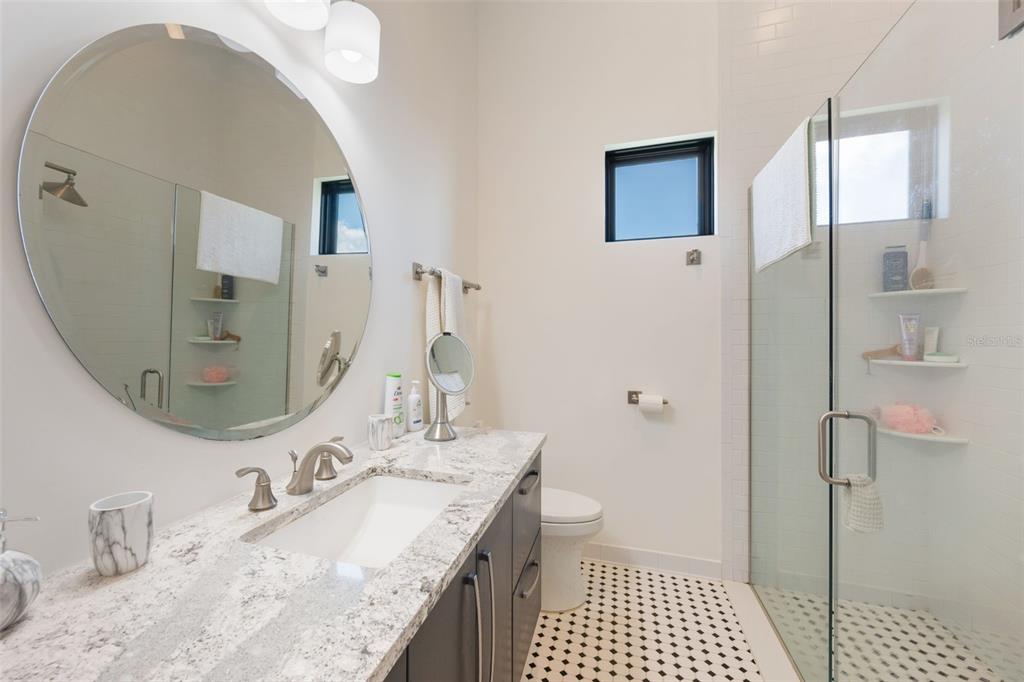 17640 Broad Street Montverde, FL 34756 - Photo 19 of 48 a bathroom with a granite countertop sink a mirror and a shower